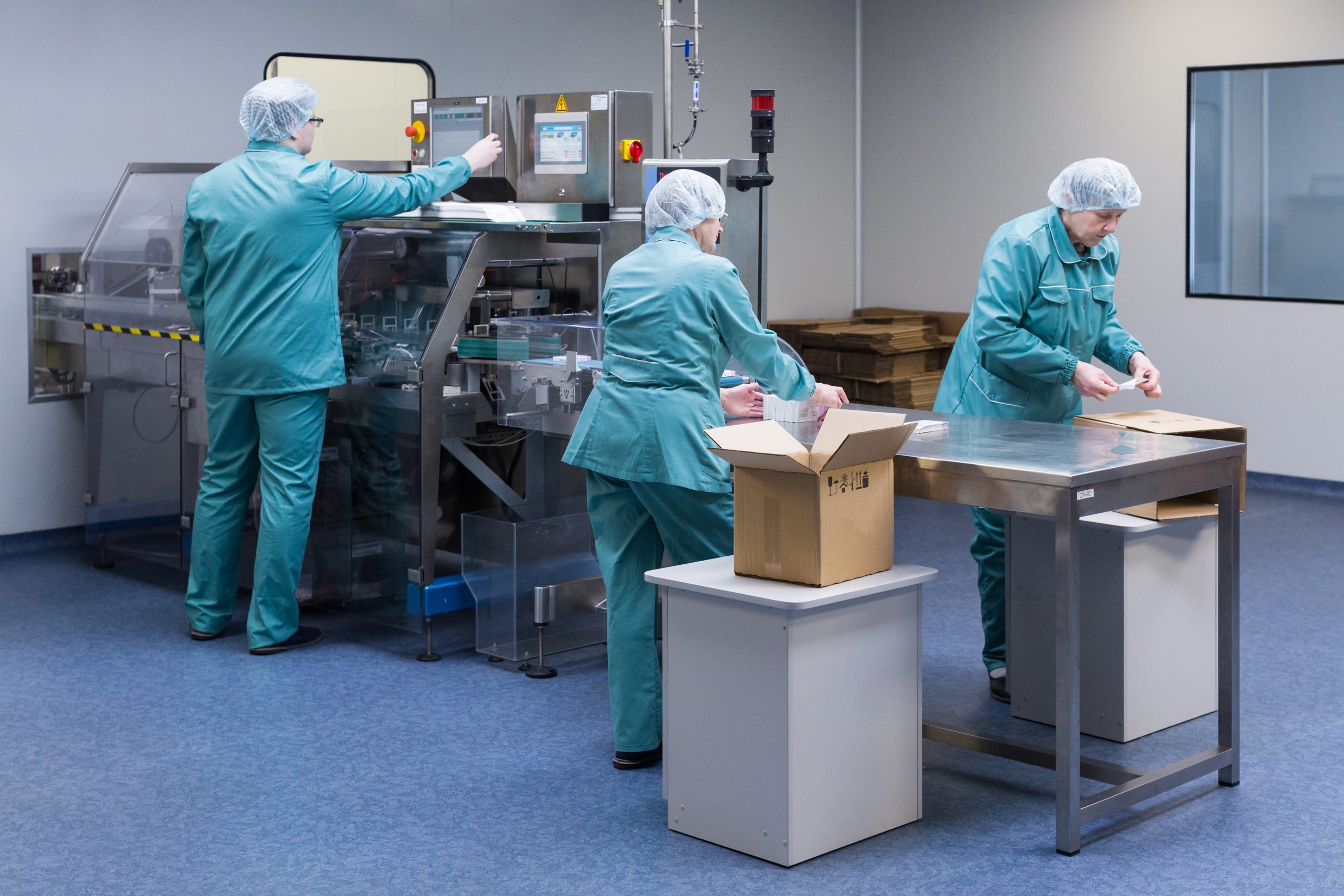 Pharmaceutical factory workers in sterile environment Pharmaceutical factory workers in sterile environment